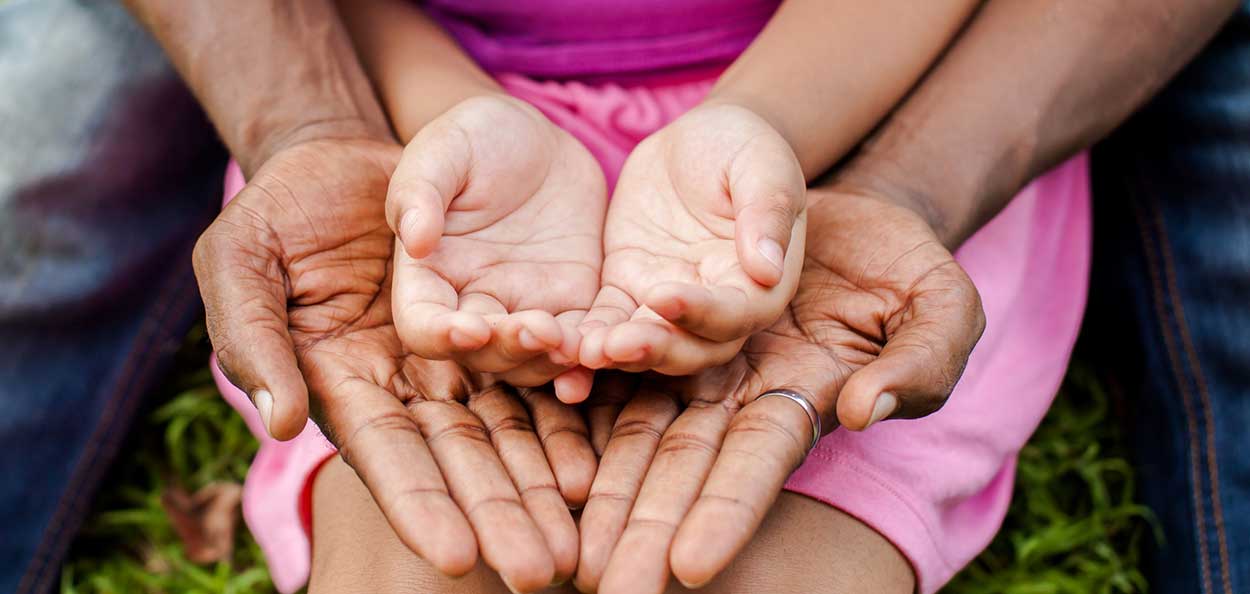 Childs open hands resting inside their grandparents'